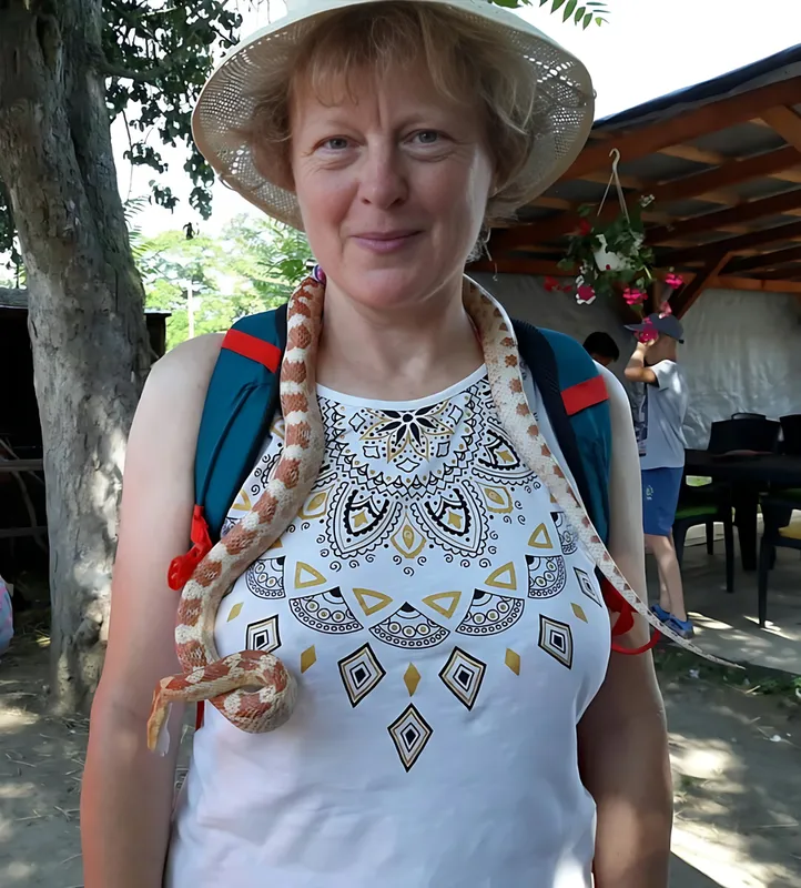 Autorka s kloboukem a batohem, kolem krku má užovkučervenou